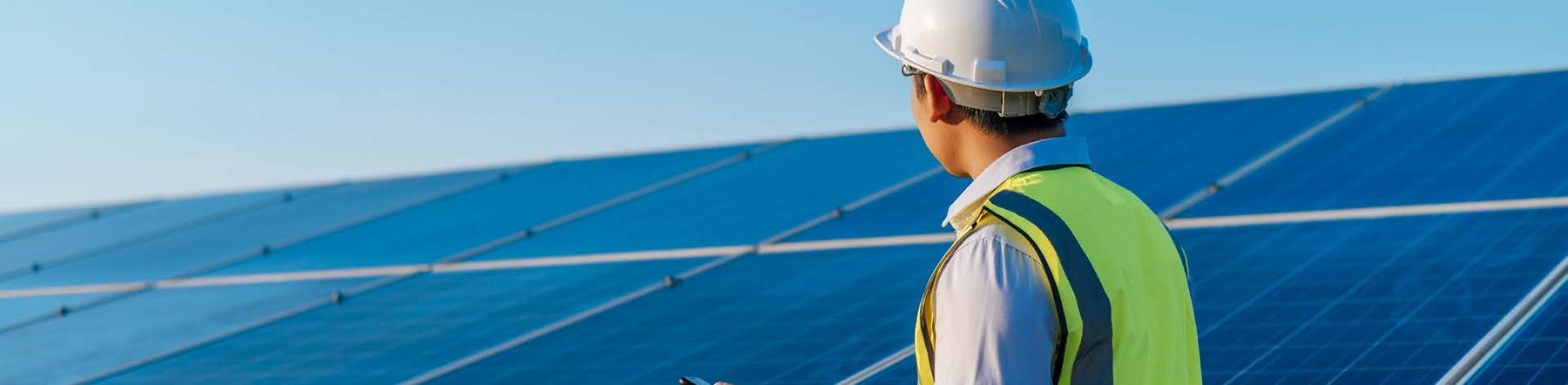 Engineer inspecting a large solar photovoltaic array